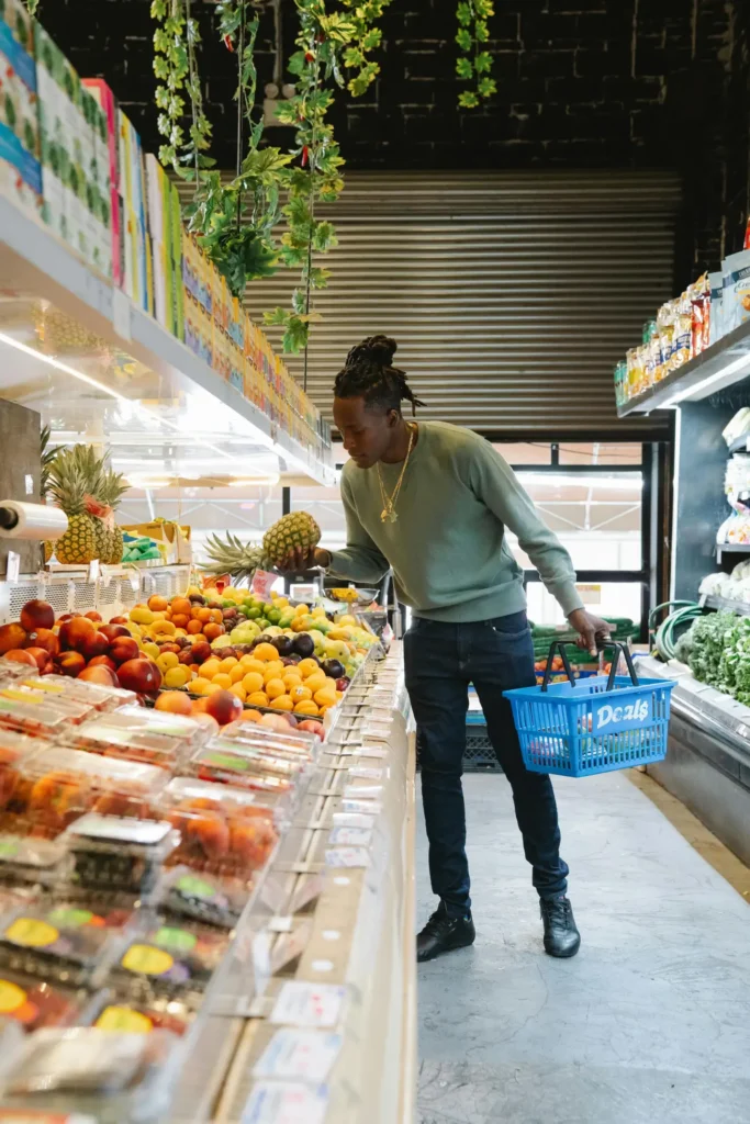 Man in grocery store picking pineapple